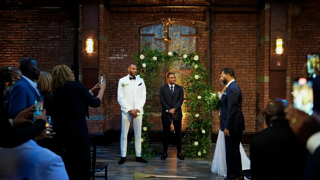 Indoor wedding ceremony with floral arch, brick walls, warm ambient lighting