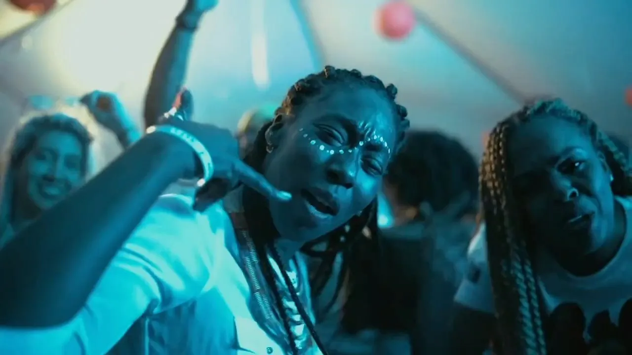 Crowd of people dancing and pointing under blue nightlife lighting