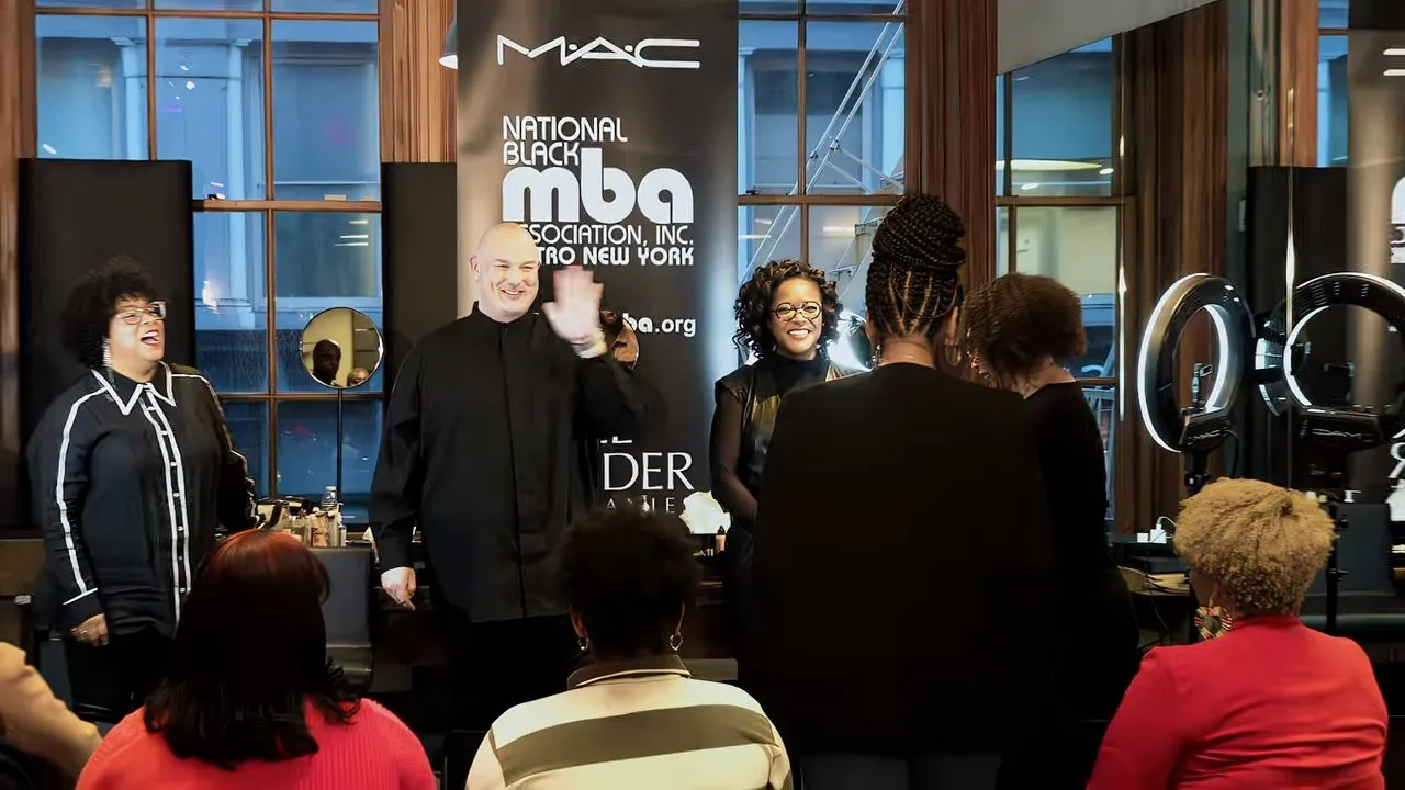 People gathered at branded conference booth with MAC and MBA signage
