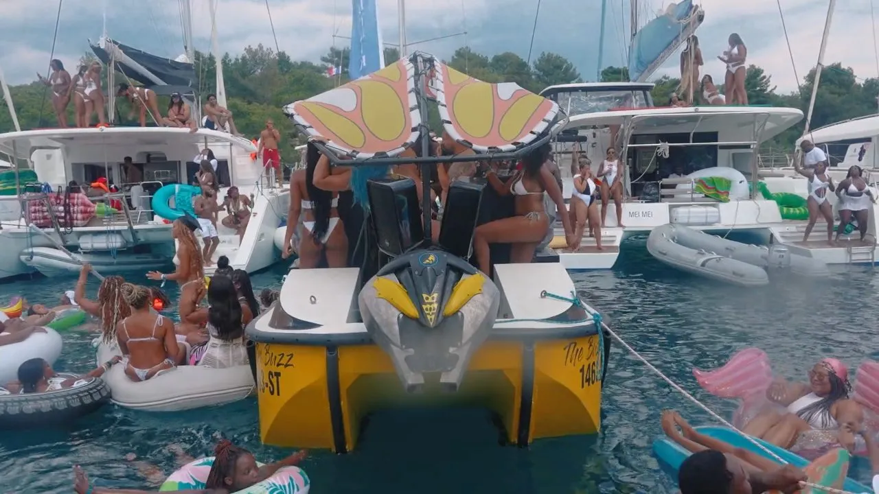 Inflatable water slide and floats among yachts in a bay