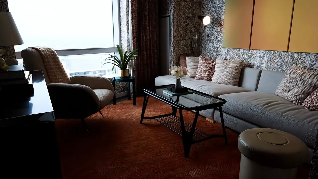 Modern hotel suite lounge with sofa, coffee table and window view