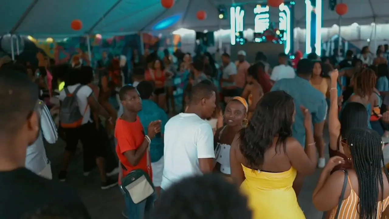 Crowd of people dancing under a large white tent at outdoor festival