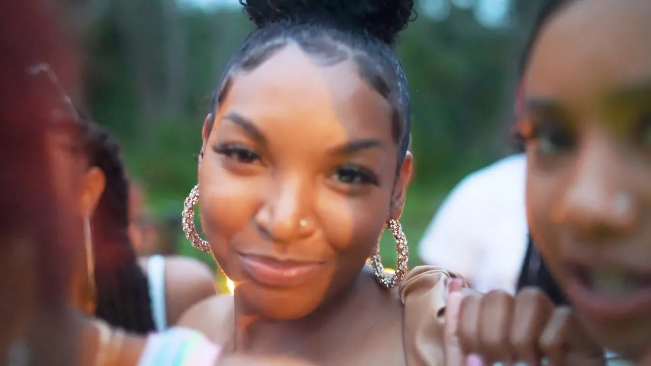 Smiling woman with hoop earrings looking at camera in crowd