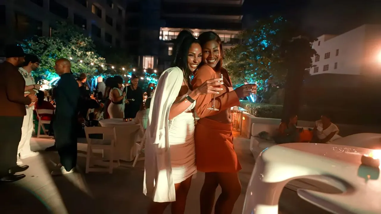 People socializing at dimly lit outdoor evening party with string lights
