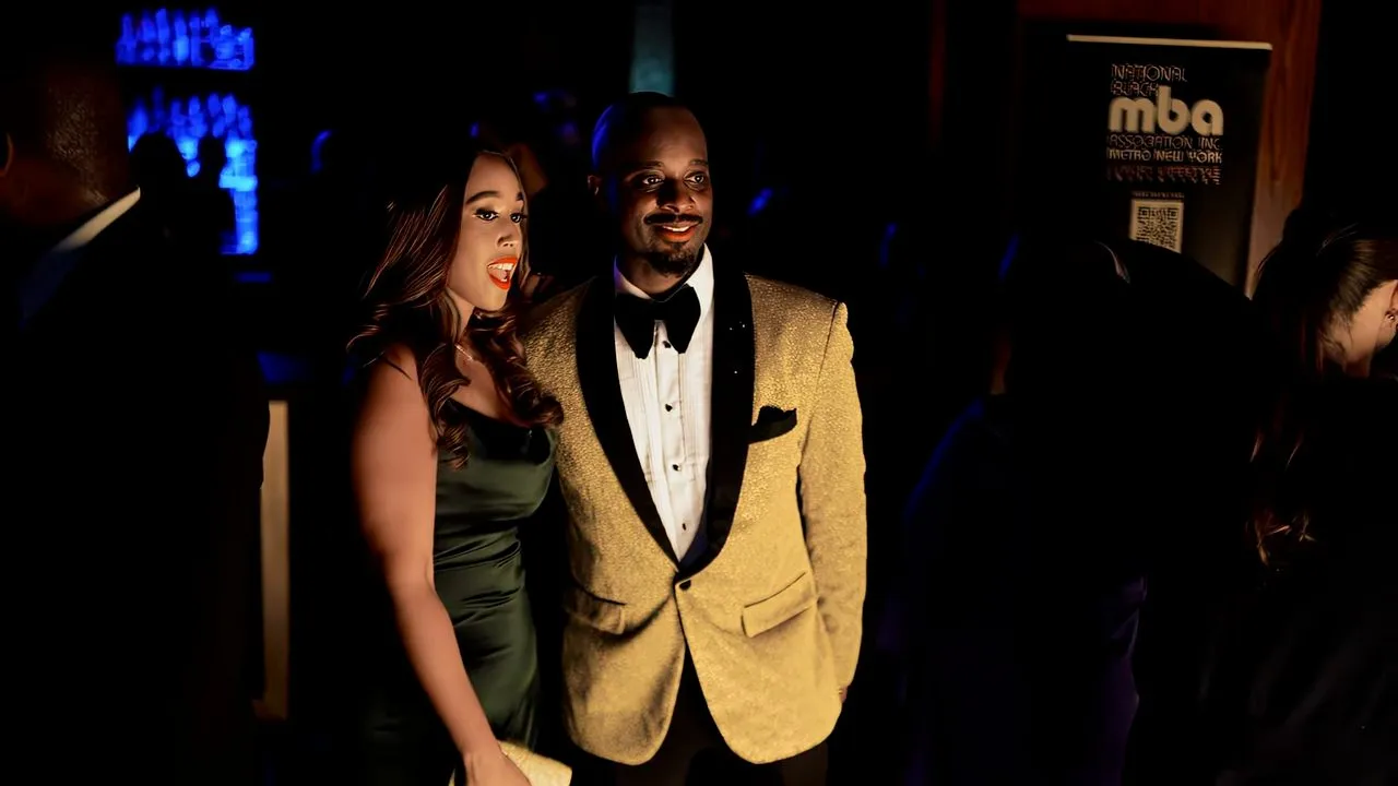 Couple in formal attire posing together at a dark evening event