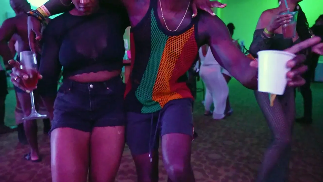 Two people dancing close together holding cups on party dance floor