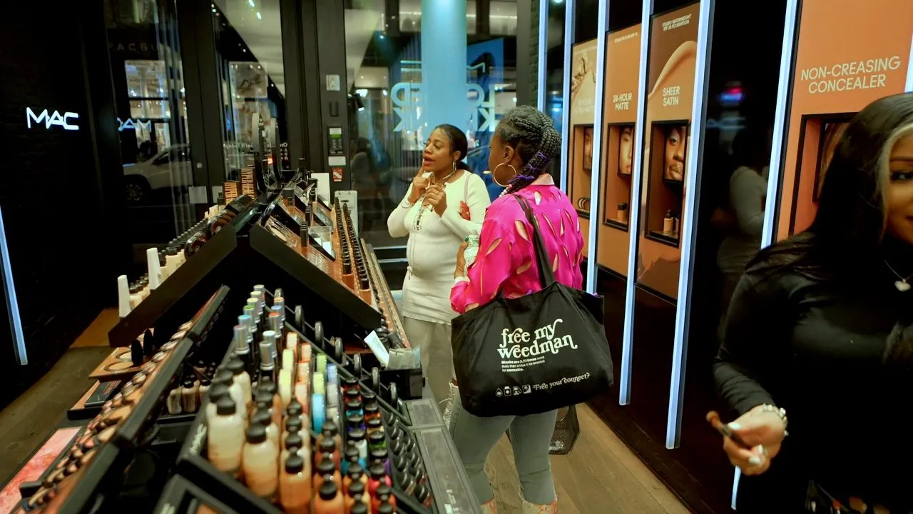 Shoppers browsing colorful makeup shelves in MAC cosmetics store interior