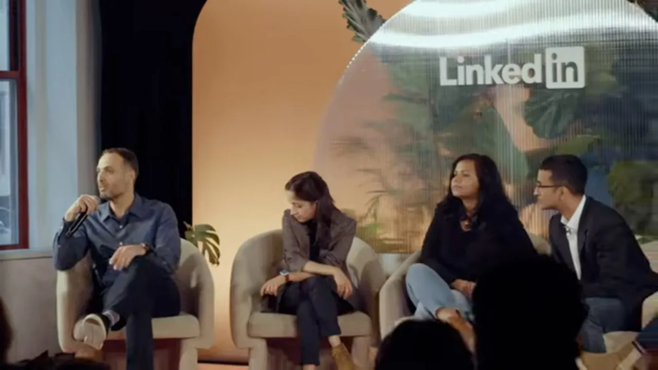 Four panelists seated in armchairs onstage, LinkedIn logo on backdrop screen