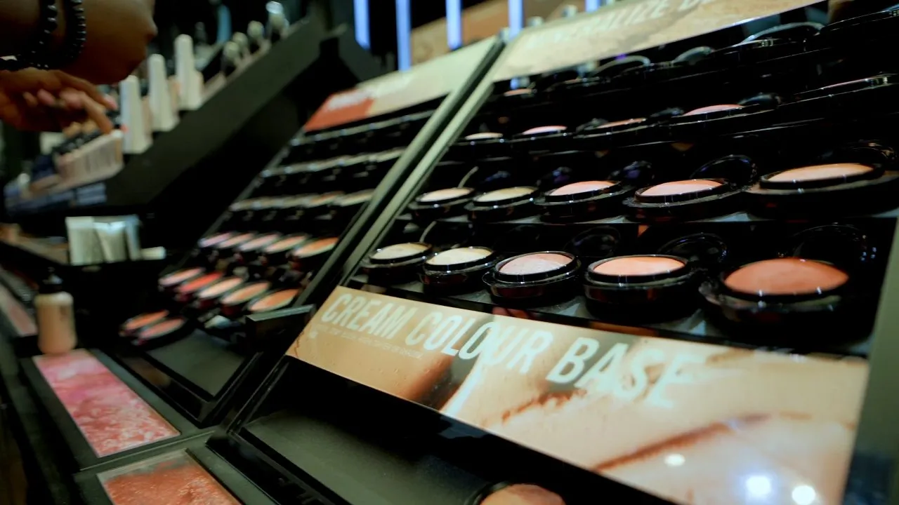 Makeup palettes and eyeshadow compacts arranged on angled retail display