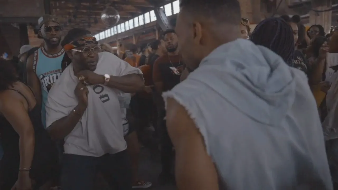 People in casual clothing mingling in crowded brick warehouse party space